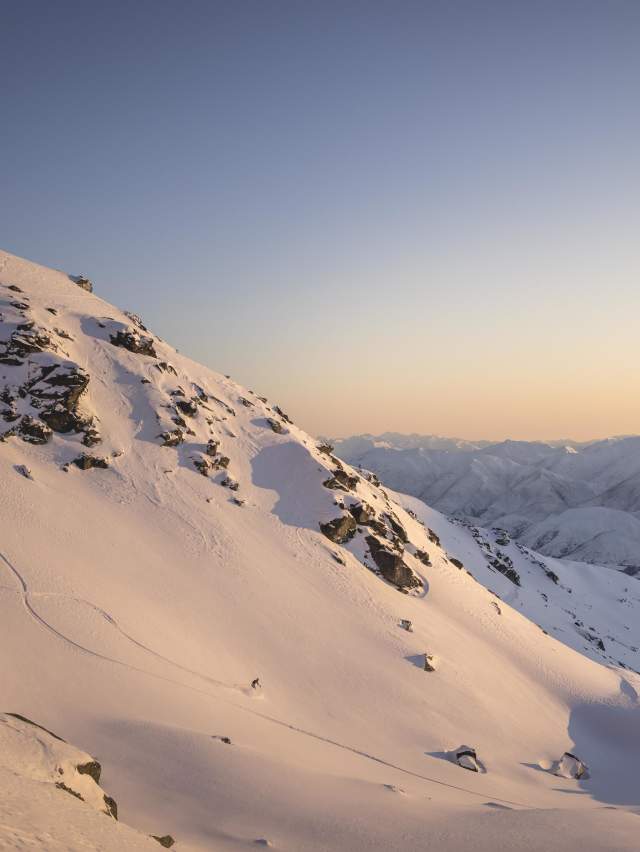 Far shot of person skiing at the Remarkables ski aera at sunrise