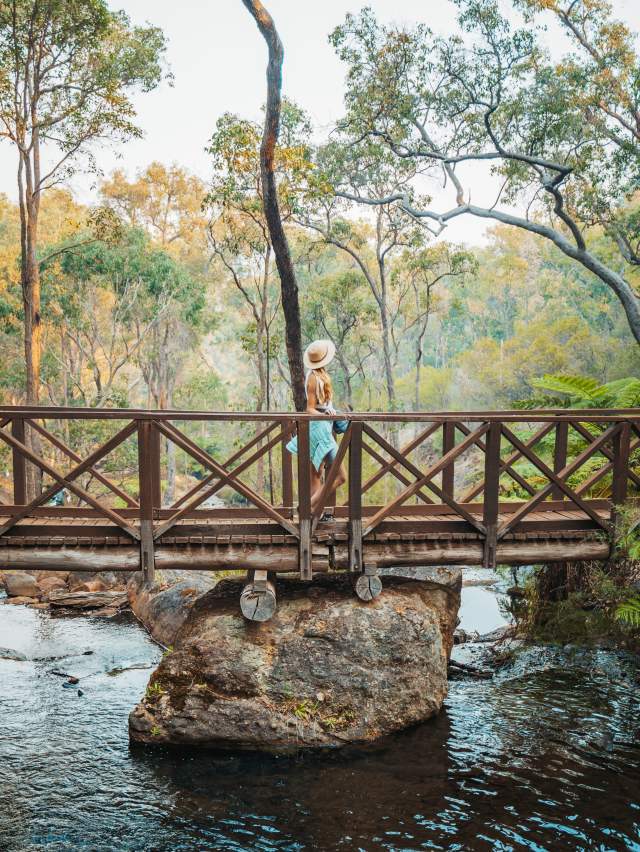 Girls walks across a bridge at Araluen Botanic Park in Armadale