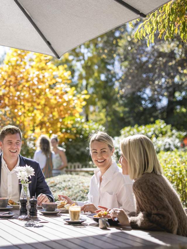 Group of people enjoying breakfast outside on a sunny autumn day