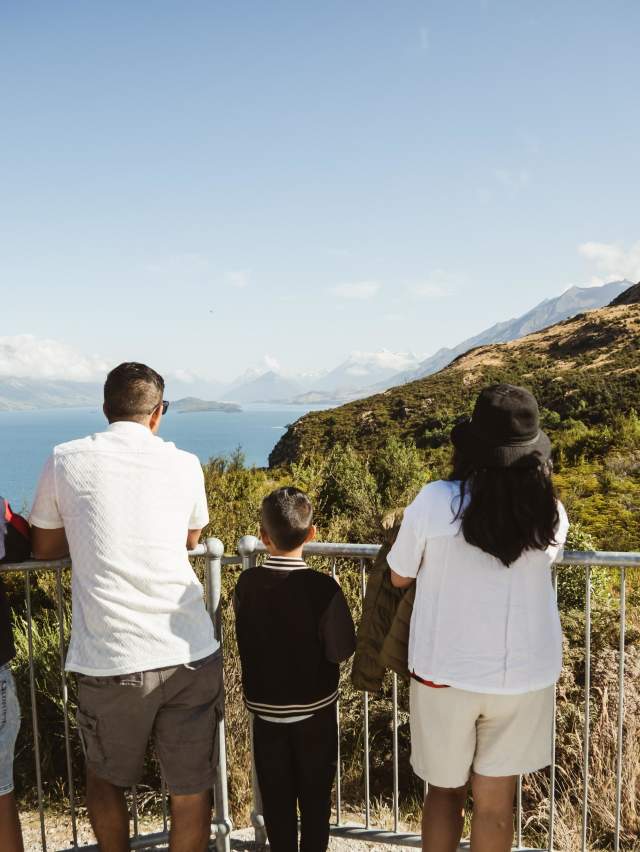 A family looking out from Bennetts Bluff Viewpoint Walk towards Glenorchy on a blue bird day with Altitude Tours