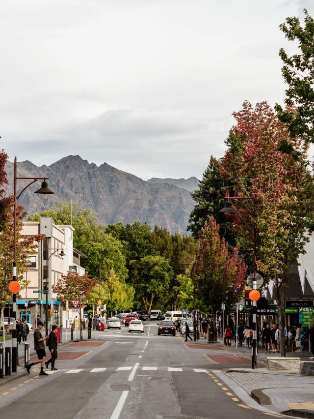 Queenstown town road with colourful trees and mountain in the background