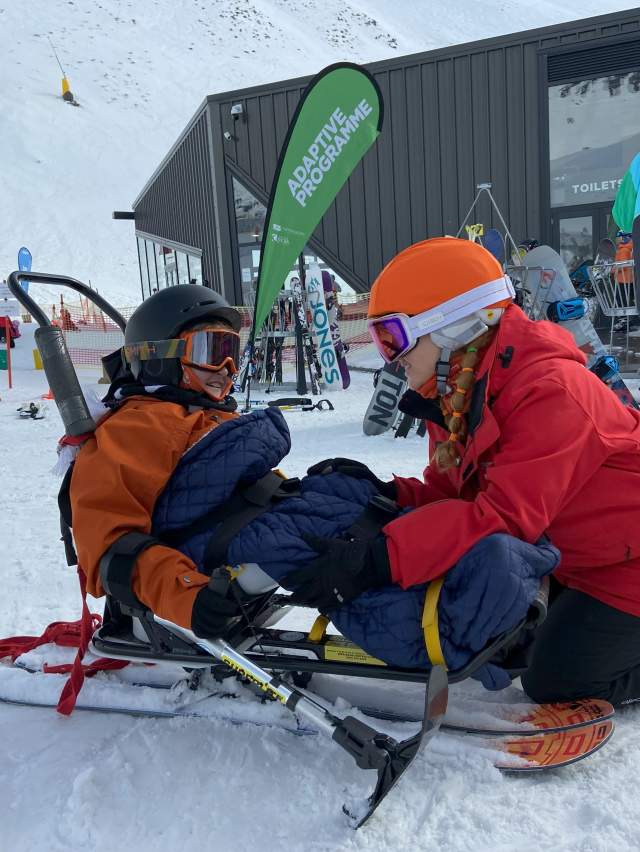Two people couching down on the snow