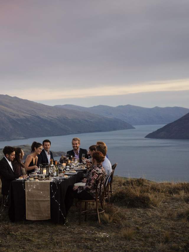 group dining on top of mountain with the Remarkables in the background