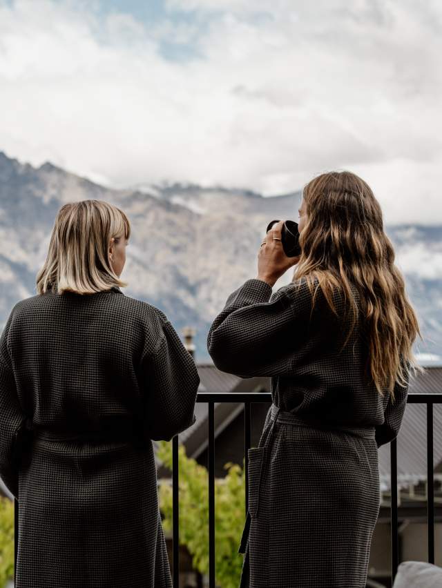 Two women enjoying coffee and view of mountains from their balcony at Kamana Lake House Hotel
