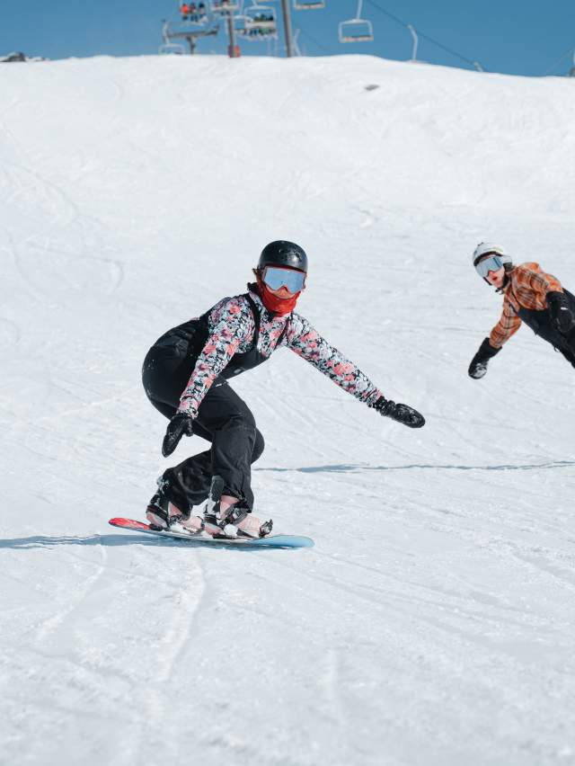 Group of snowboarders shredding Coronet Peak in spring