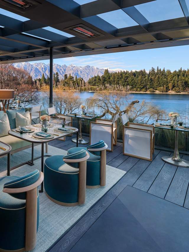 Image of high end luxury hotel patio looking with elegant tableware set up for al fresco dining, looking out over Lake Whakatipu and The Remakables.