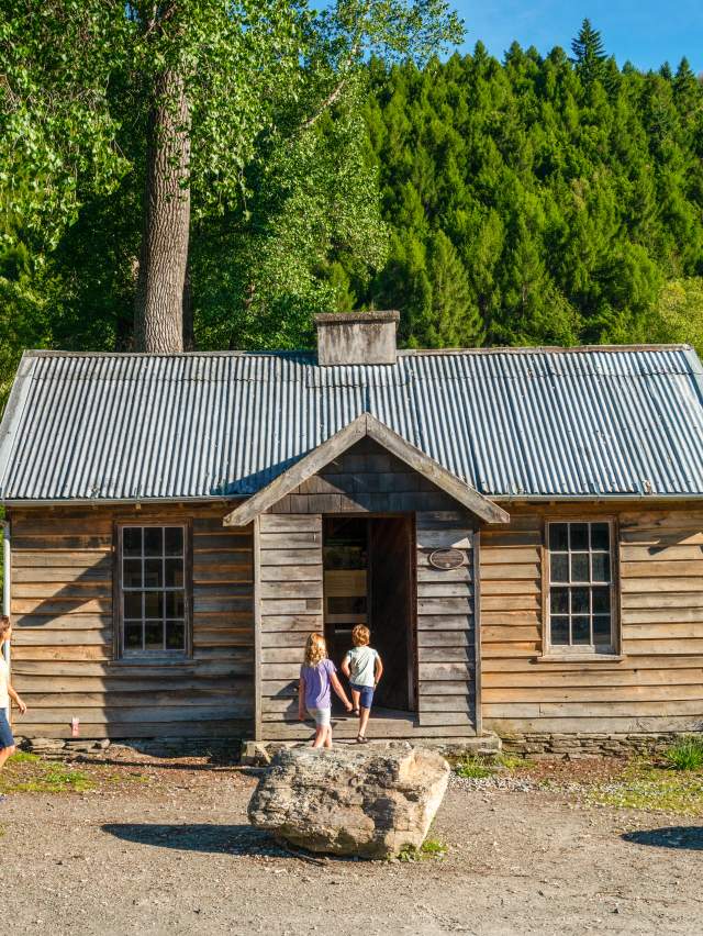 Family in front of the historic Arrowtown Police Hut