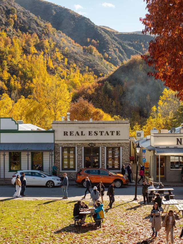 Street view of an old historic town with autumnal trees and mountains in the background