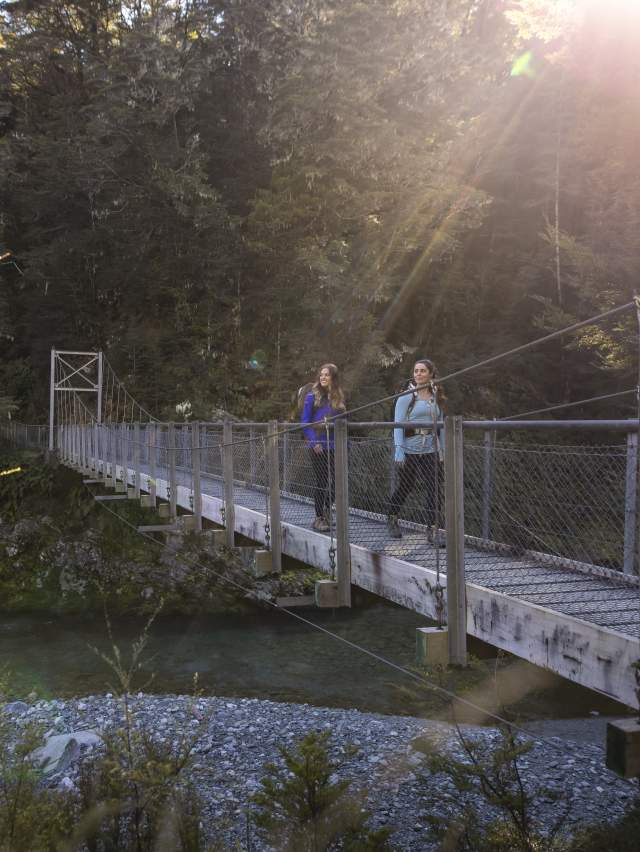 Two female hikers on the Routeburn Track swing bridge