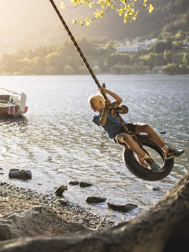 Family playing on rope swing in Queenstown Gardens