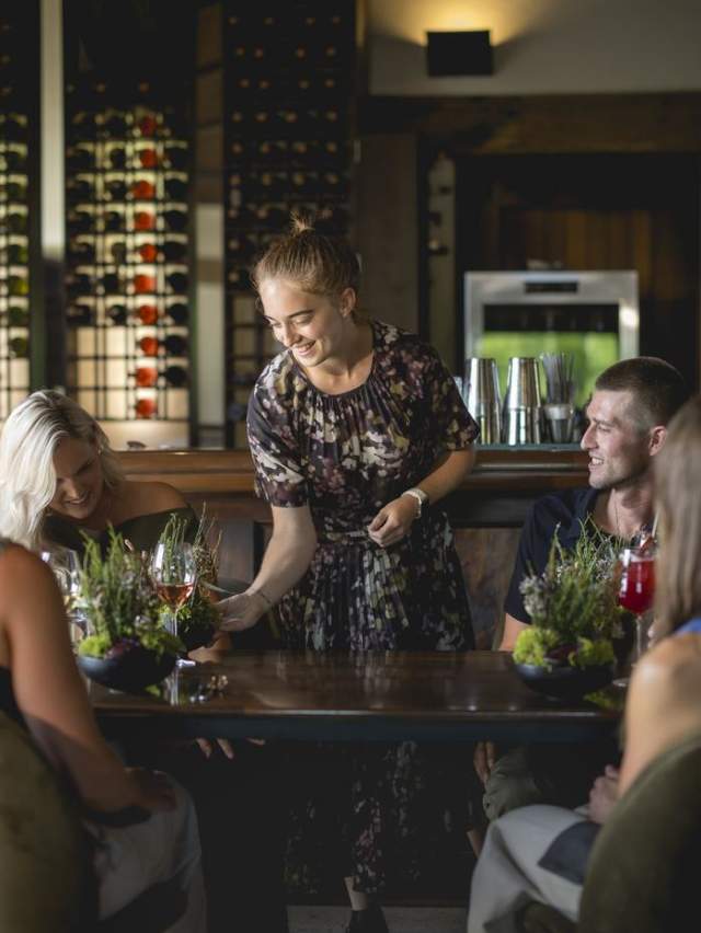 A waitress serving a group of diners at Amisfield Restaurant