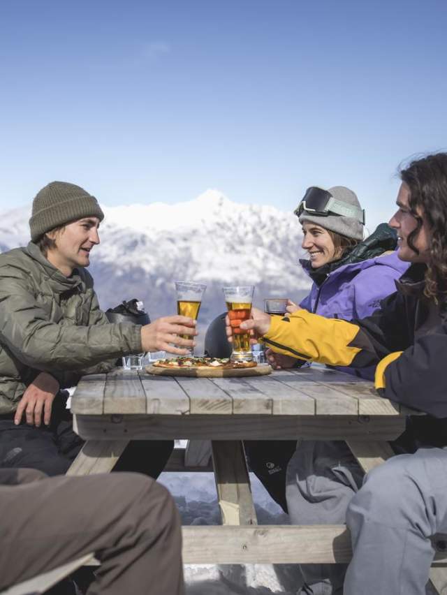 Group of friends enjoying a drink a the top of a mountain