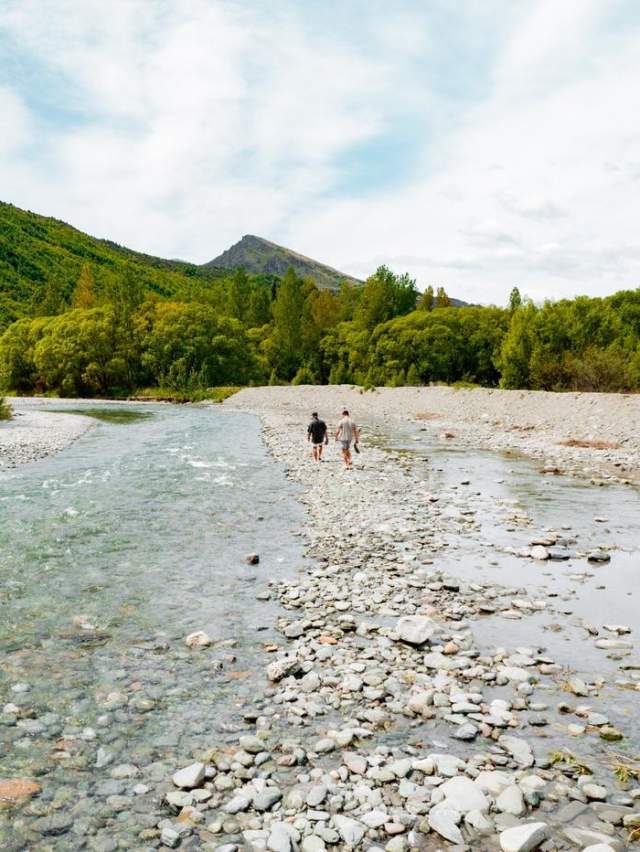 Two people walking the Arrow River, Arrowtown