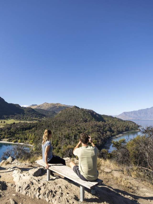 Three people enjoying sweeping mountain and lake views on the Bob's Cove look out point