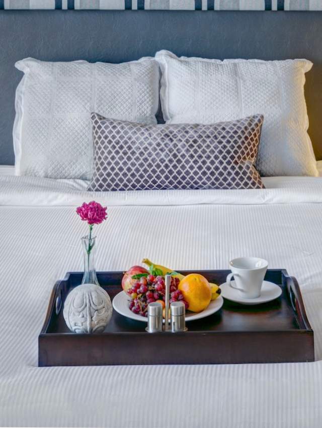 A king sized bed with lush bedding and a breakfast tray is waiting for you in a hotel room in Fort Smith.