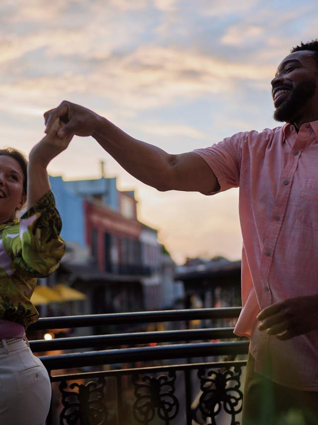 A couple dances on a French Quarter balcony