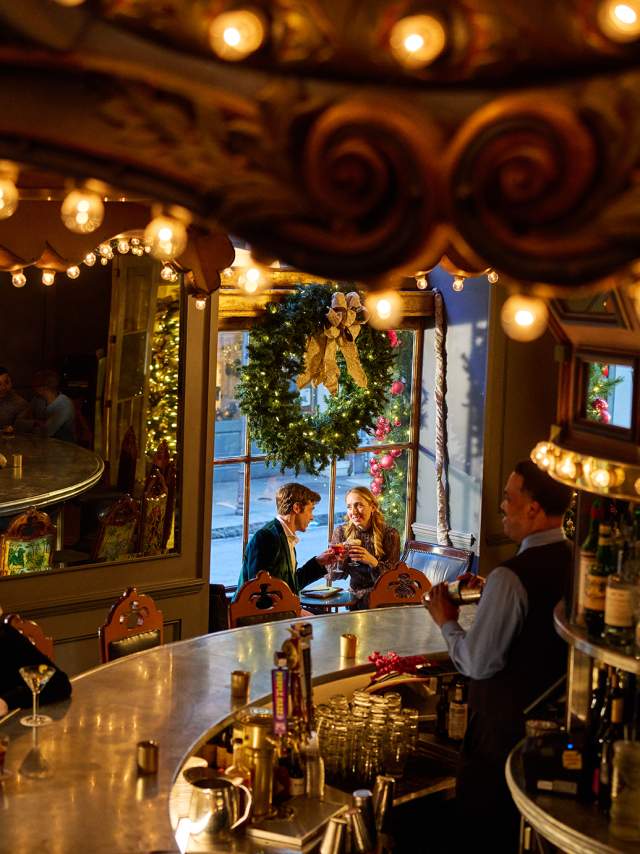 A couple enjoys holiday cocktails in the festive environment of the Carousel Bar in Hotel Monteleone.