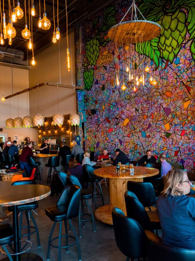 People drinking inside Kros Strain Brewing.