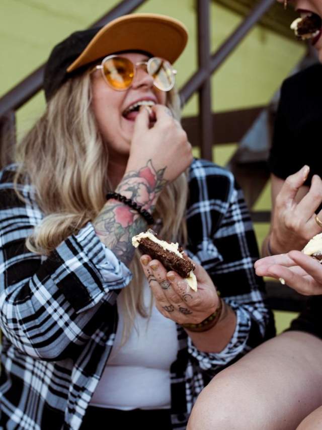 Two people eating a frosted treat.