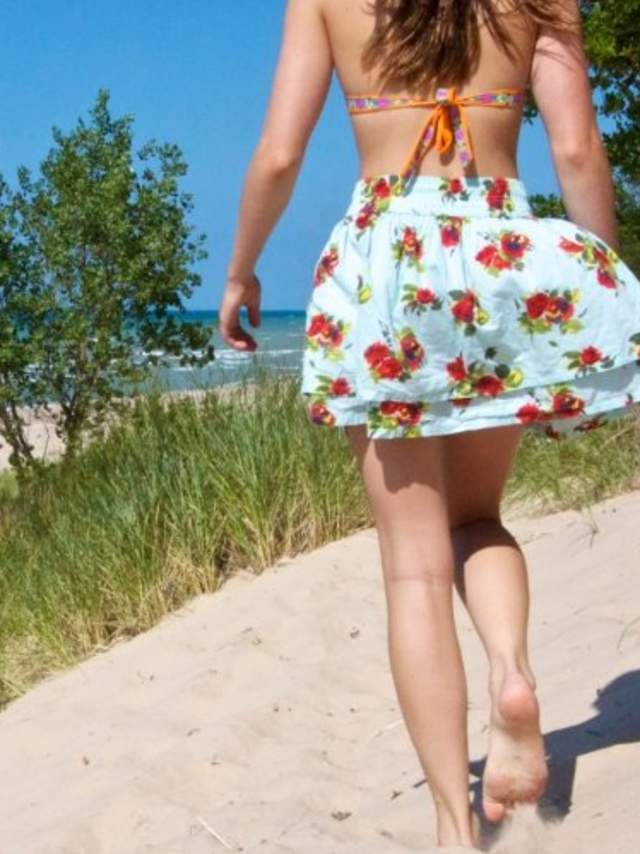 Woman walking on beach dunes