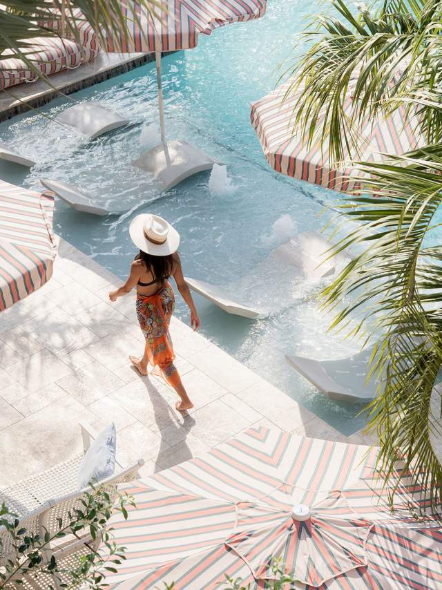 A woman walks by the pool at the Garden District Hotel in New Orleans