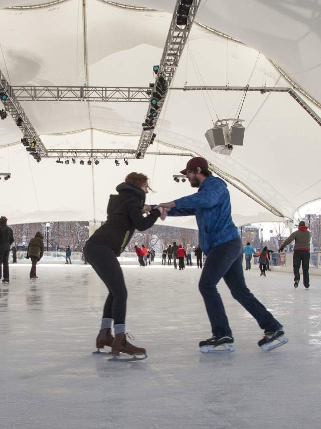 a man and a woman ice skating at the RiverScape ice rink