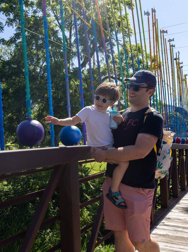 Father and son crossing a colorful bridge at Smoky Hill River Festival in Salina, KS