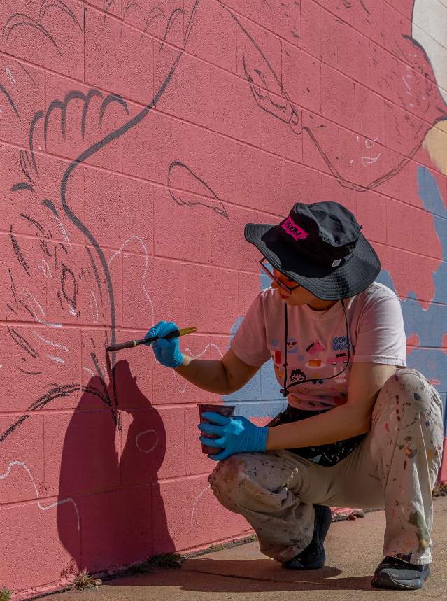 BOOM! Salina artist Amy Sol painting her mural titled "Carrying Home" in Salina, Kansas