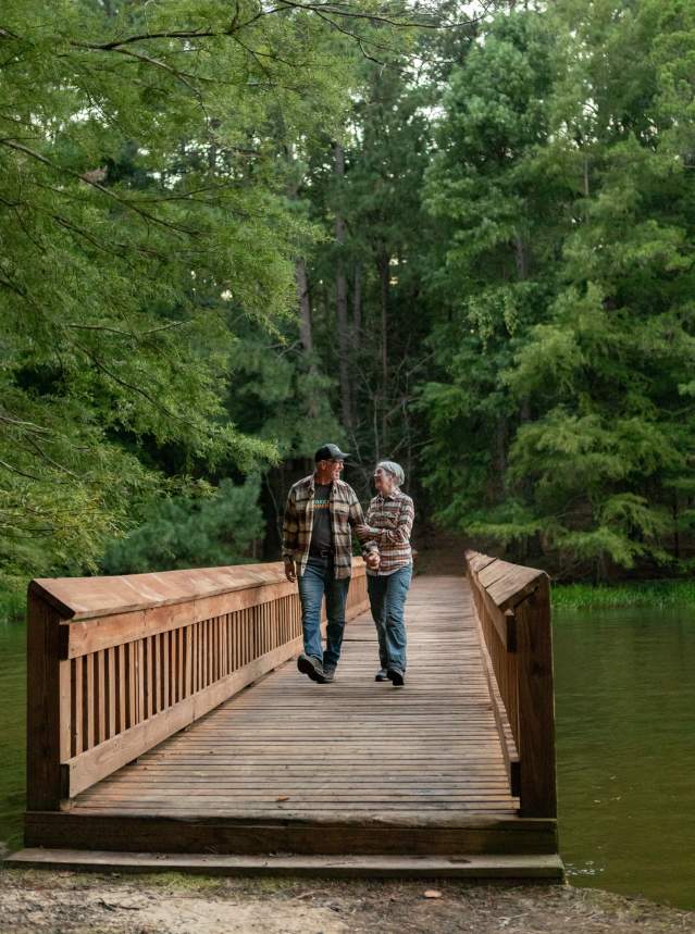 Couple Walking on Bridge in Wooded Area