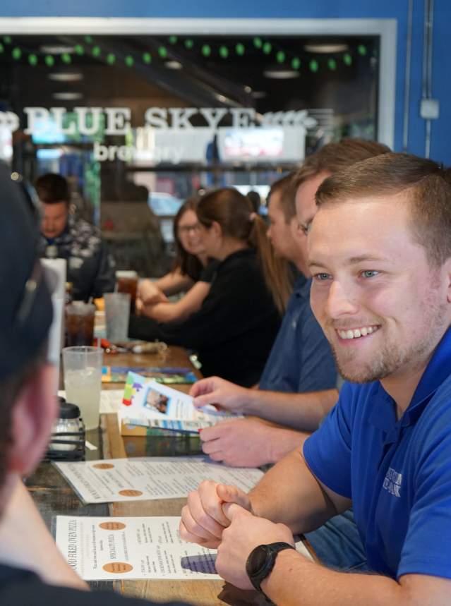 A guy smiling in a group of people at Salina Young Professionals Lunch Club in Salina, Kansas