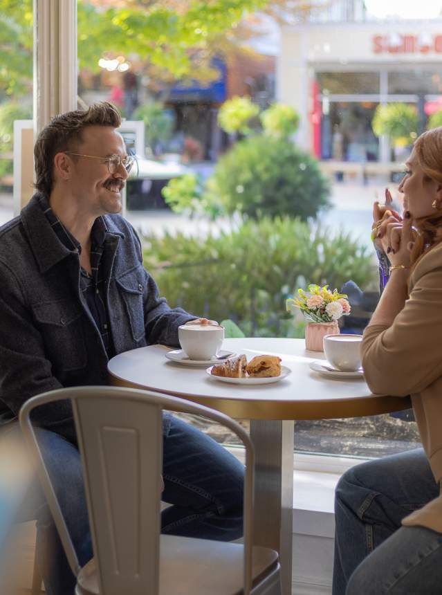 Couple chatting in a cafe window seat