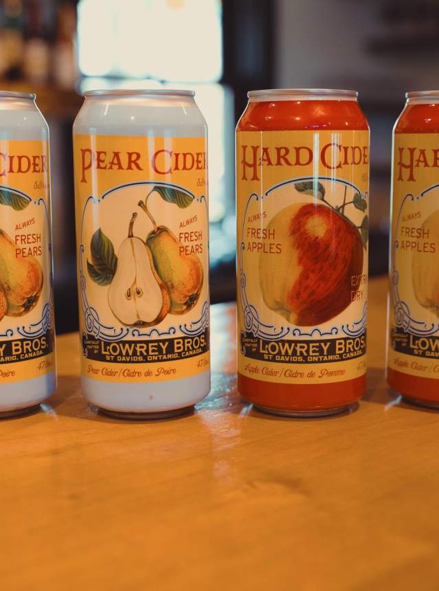 Four cans of cider sitting on a countertop