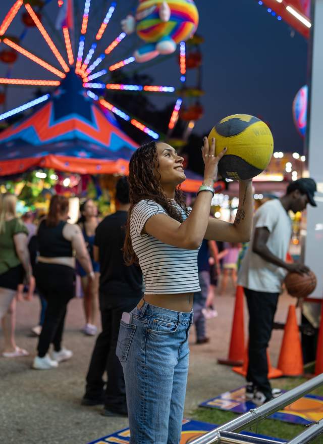 People throwing basketballs at one of the games at the Ingham County Fair