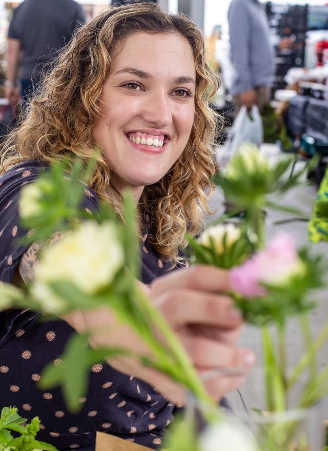 Sara reaches over to look at some flowers