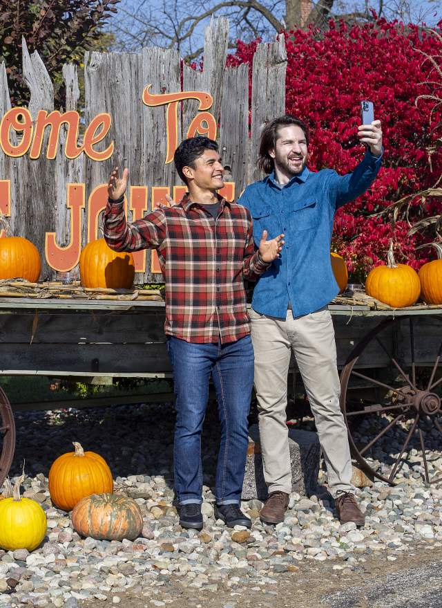 Two people taking a selfie in front of the Welcome to Uncle John's sign