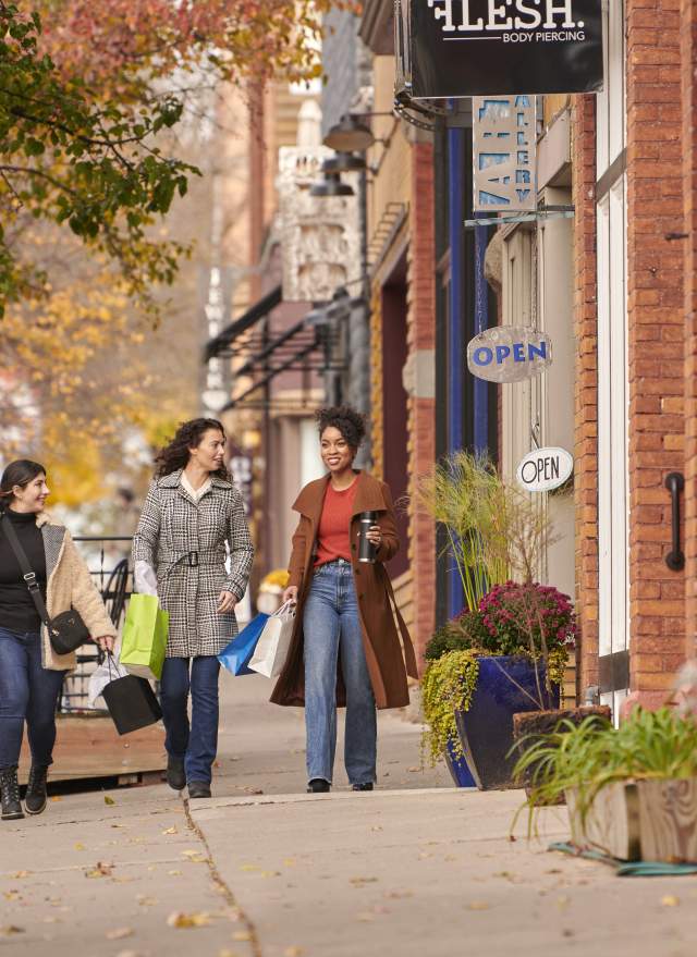 Three women shopping together in the vibrant Old Town Lansing, exploring local boutiques and enjoying the unique shops in this artsy district.