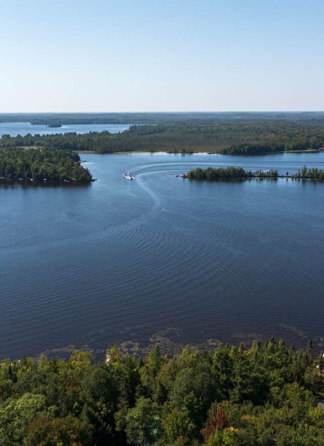 Boats on a chain of lakes, within the trees, taken by drone