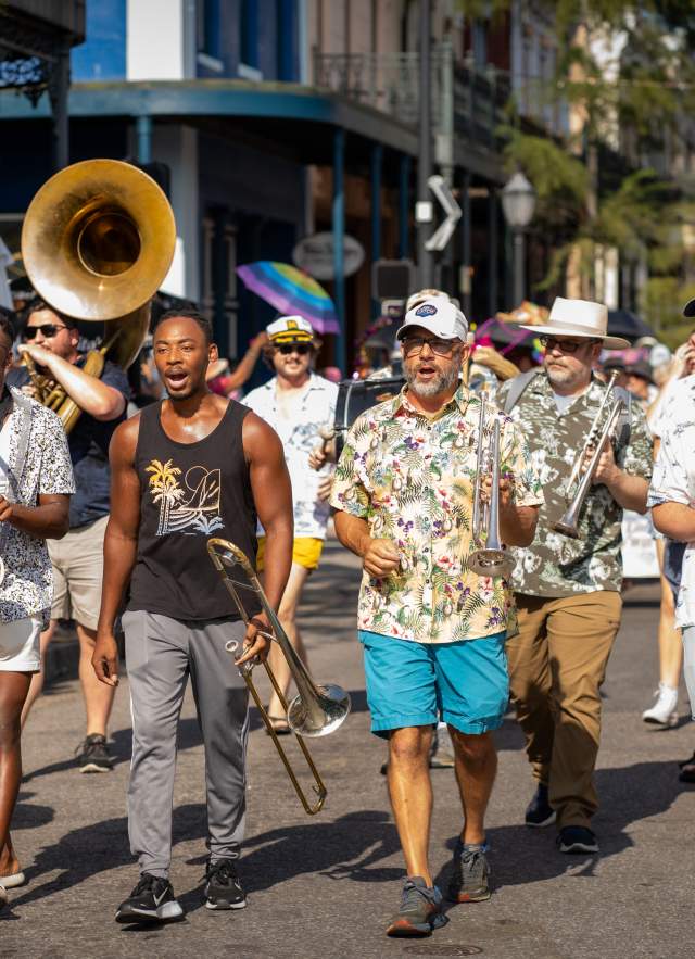 A group of musicians walking down Dauphin Street in downtown Mobile.