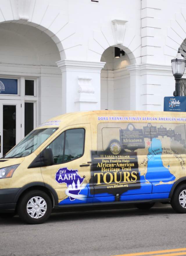 colorful passenger van parked in front of white building