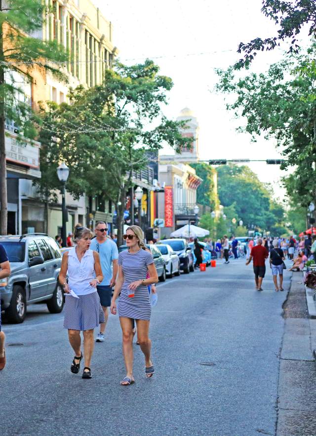 group of people walking downtown Dauphin Street