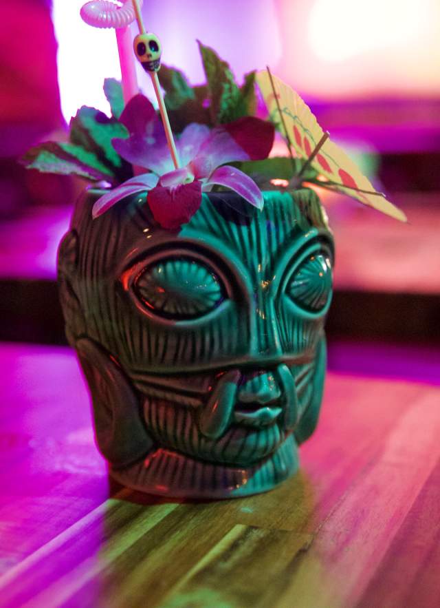 Tiki themed cocktail shot in colorful light.