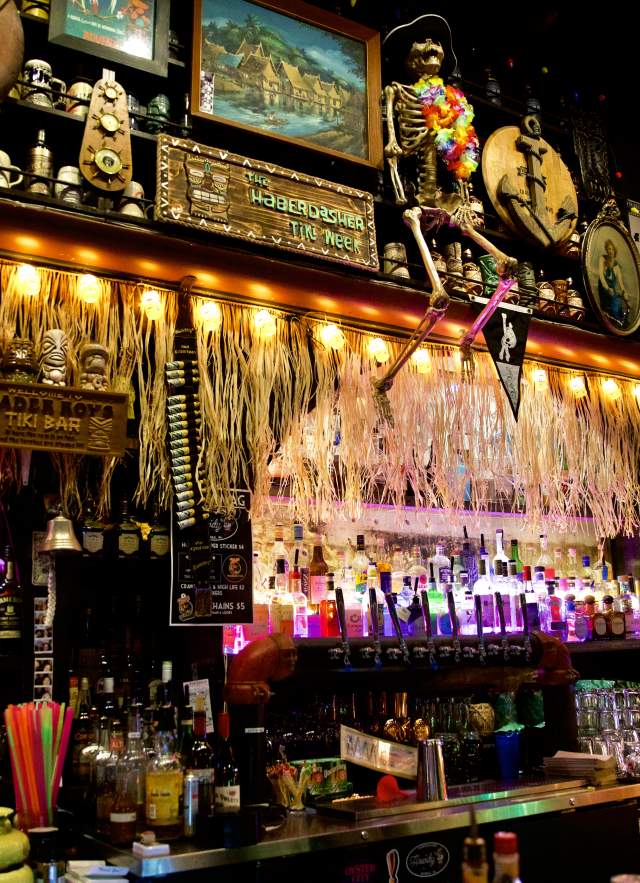 Bar decorated with hula skirts, flags and a skeleton.
