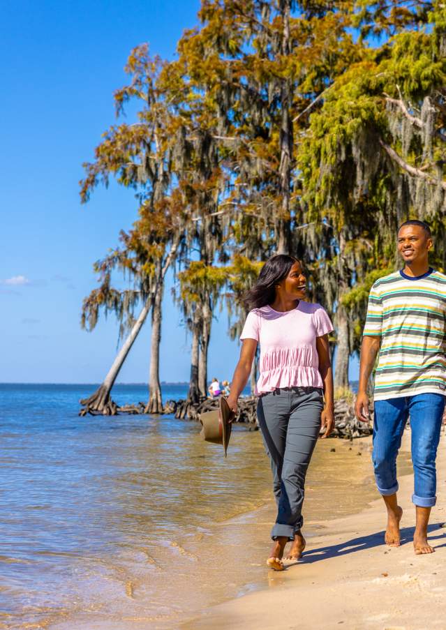 Couple walking on the beach at Fontainebleau State Park