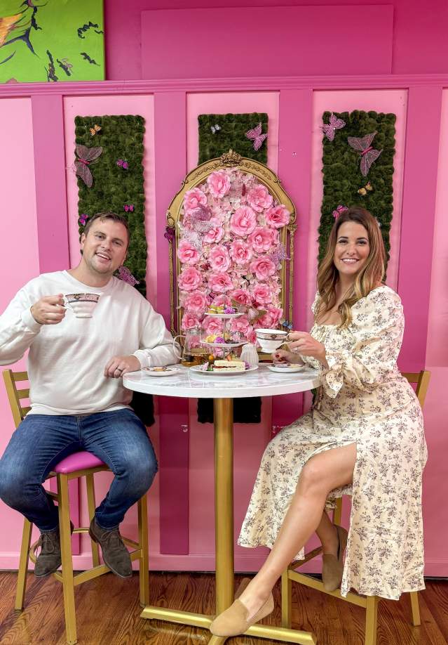 couple enjoying tea in a bright pink tearoom