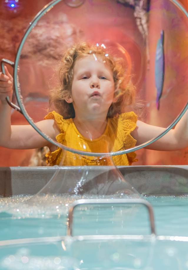 Girl blowing bubble at Customs House Museum