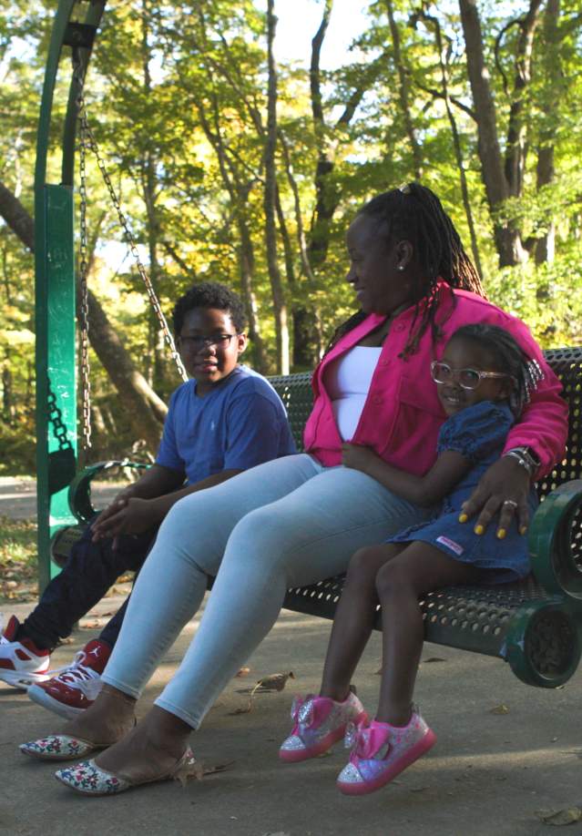 Family sitting on swing on Clarksville Greenway