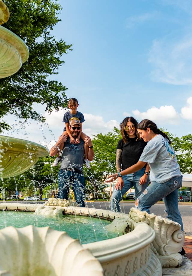family around a fountain in a downtown square