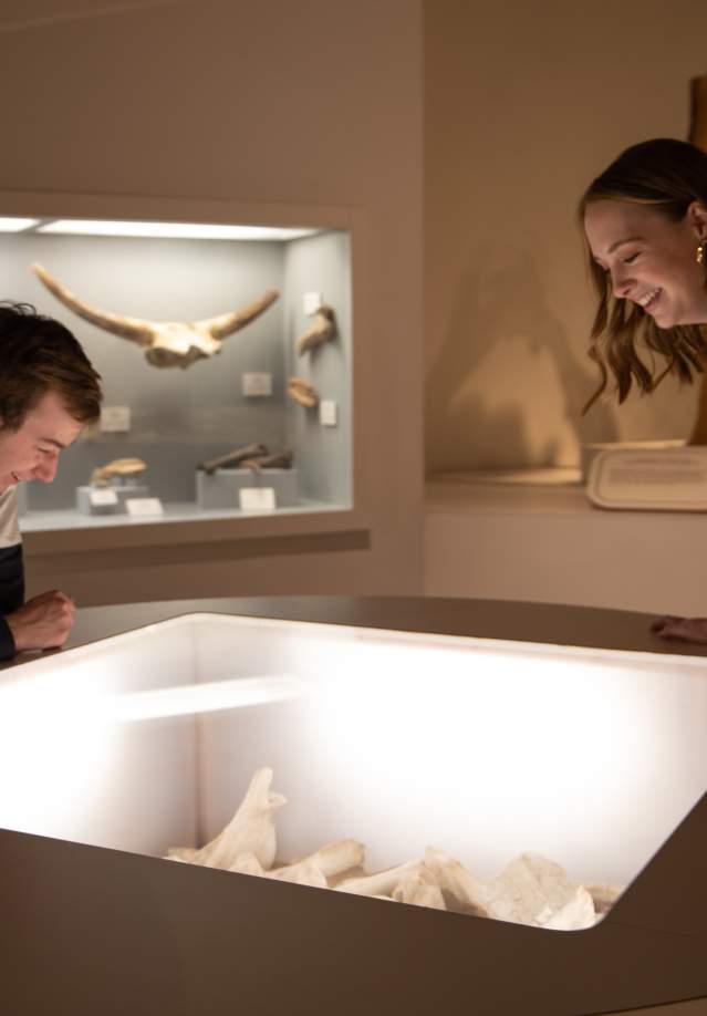 two people smiling at a museum exhibit