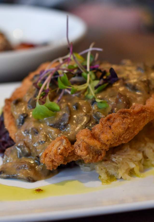 gravy-covered schnitzel on a plate
