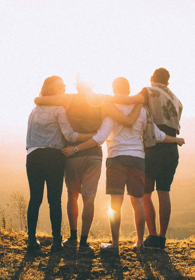 Group-friends-hugging-after-hiking-a-hill